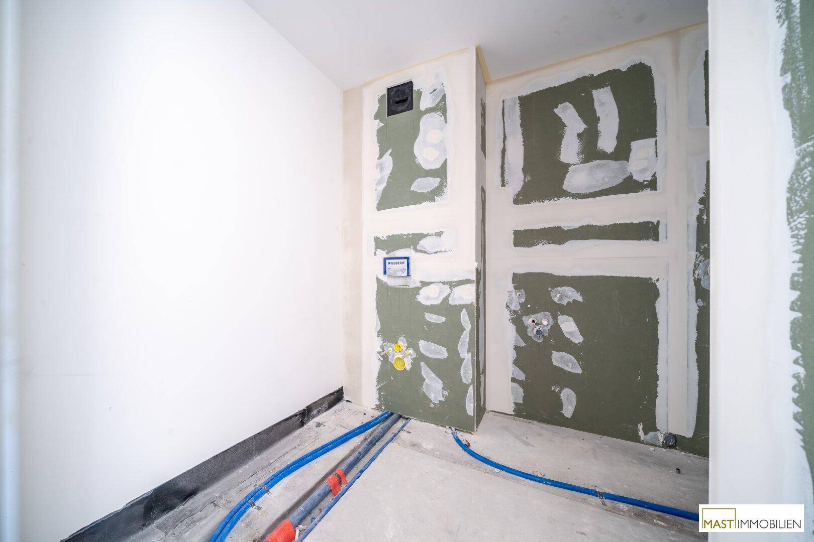 Rohbau eines WC-Bereichs mit vorbereiteten Anschlüssen und Trockenbauwänden für die Endmontage.