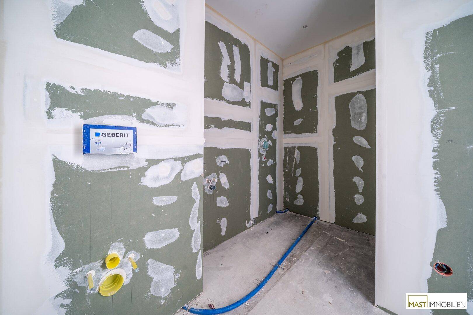 Unfertiger WC-Bereich mit sichtbaren Sanitärinstallationen und Trockenbauwänden, bereit für den Ausbau.