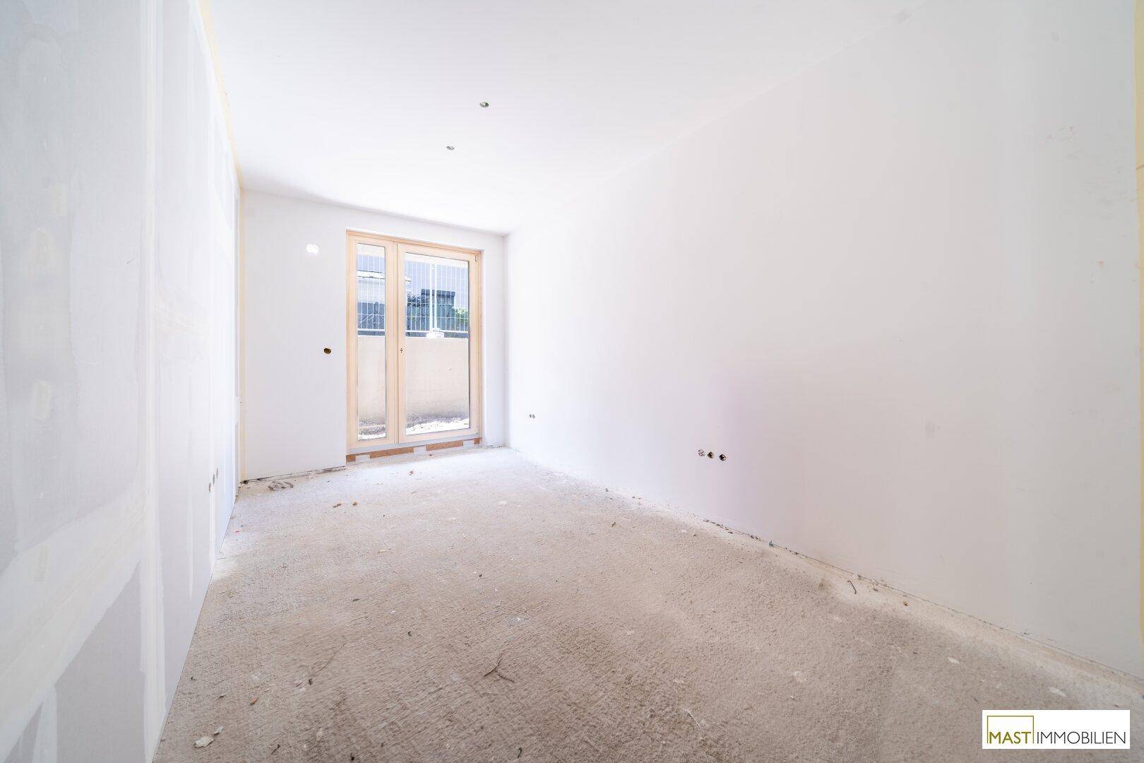 Rohbauzimmer mit großen Fenstern und Betonboden, bietet viel Potenzial für die zukünftige Gestaltung.