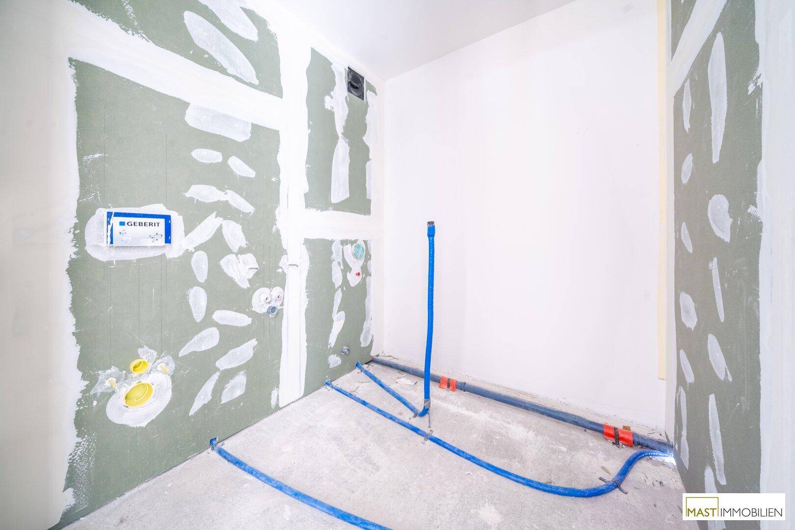 Rohbau eines WCs mit sichtbaren Sanitärinstallationen und Trockenbauwänden, bereit für die Endmontage.