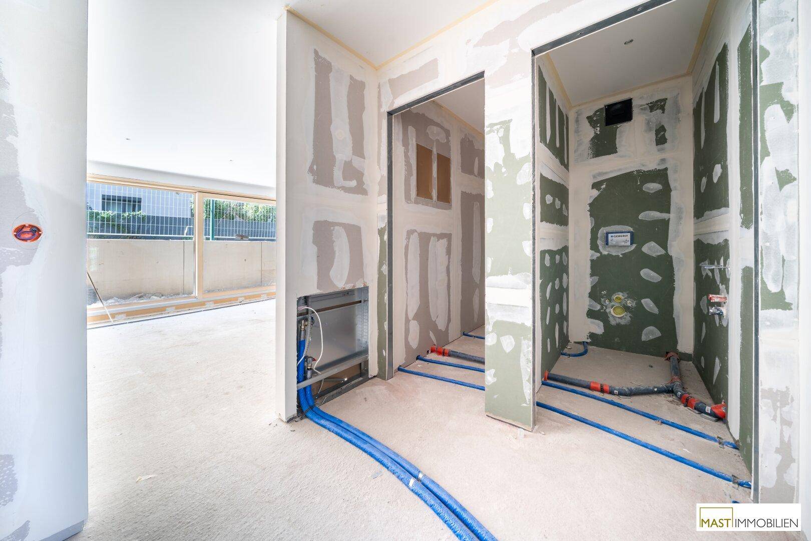 Rohbau mit vorbereiteten Anschlüssen für Sanitär- oder Kücheninstallationen in angrenzenden Räumen.