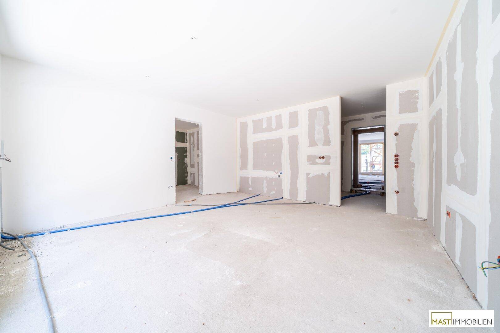 Rohbau eines Innenraums mit Trockenbauwänden und sichtbaren Leitungen für die weitere Installation.