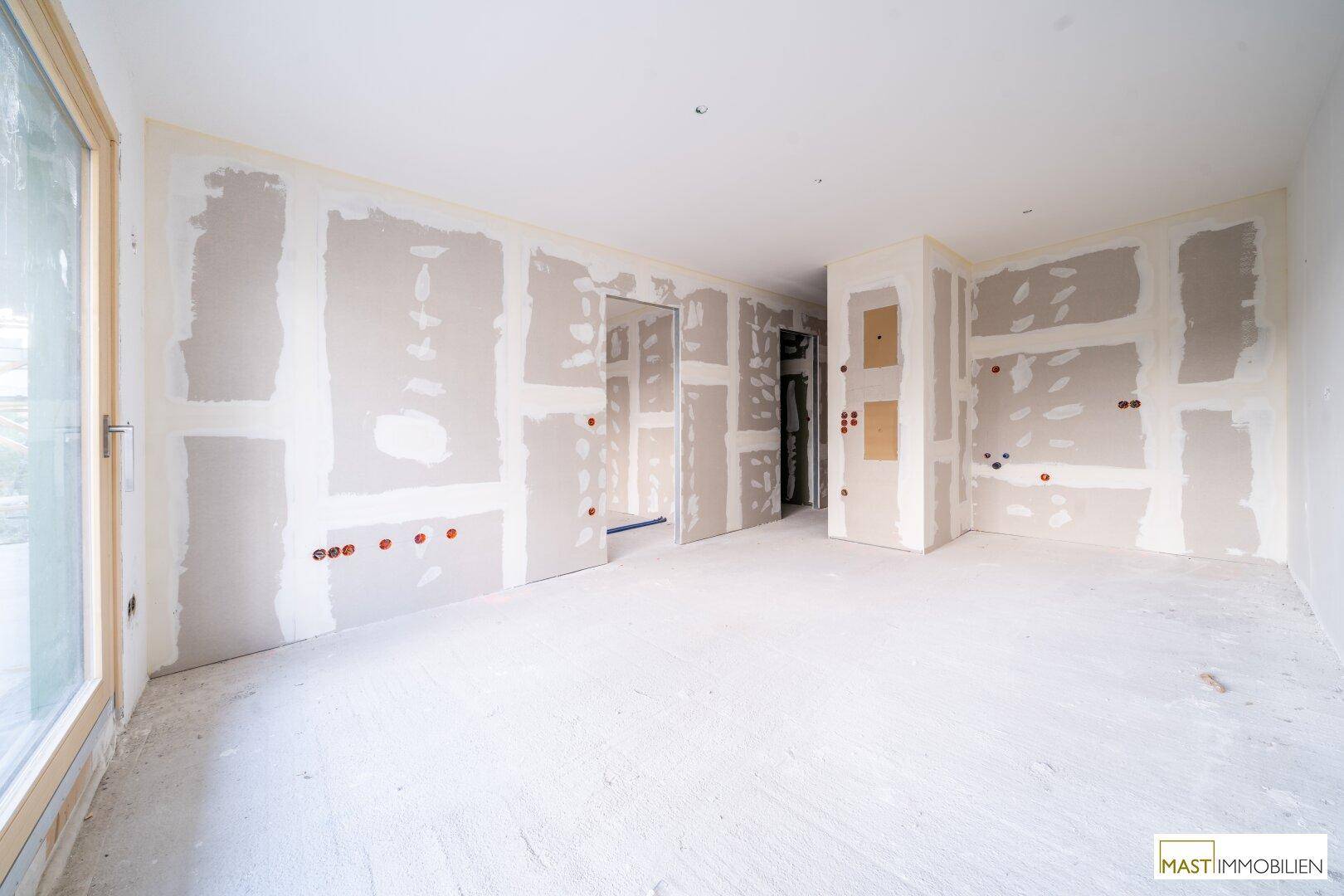 Rohbau eines Innenraums mit Trockenbauwänden und vorbereiteten Installationen für den Ausbau.