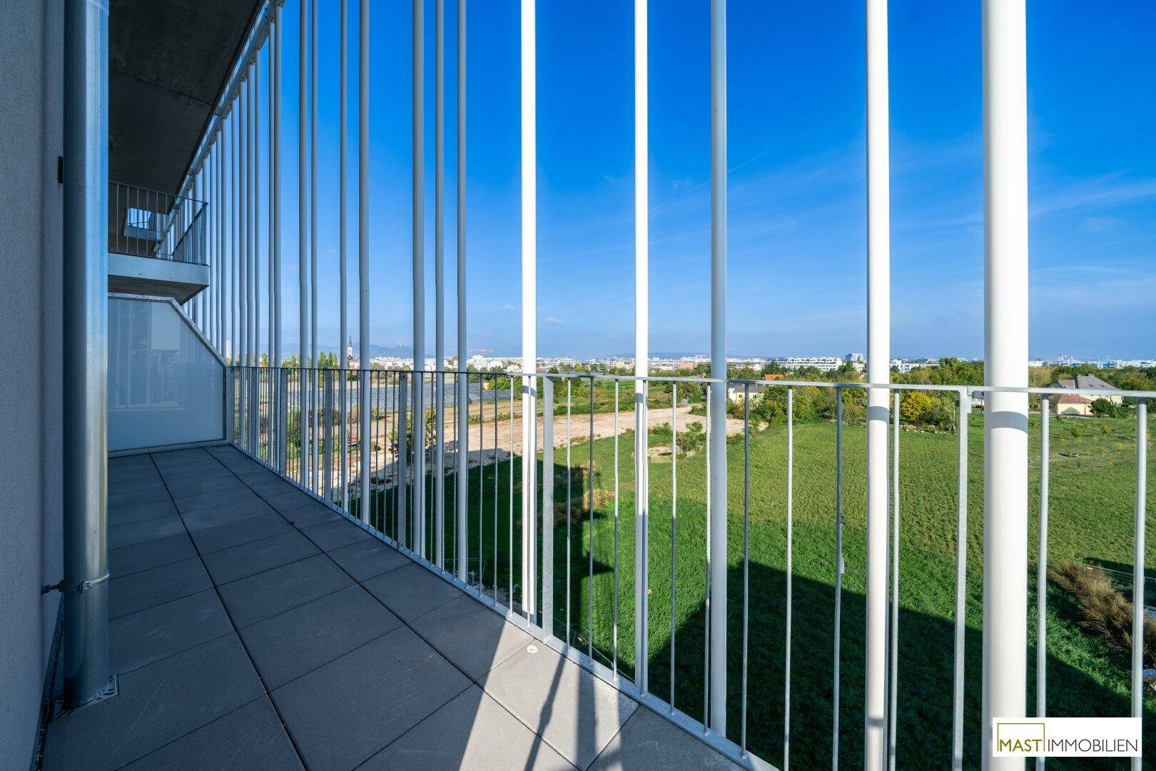 Geräumiger Balkon mit Fliesenboden und weitem Blick ins Grüne, ideal zum Entspannen.