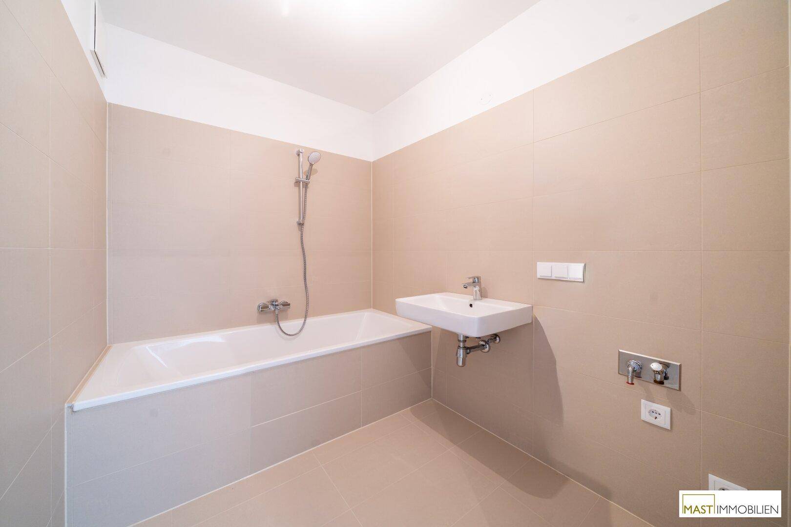 Modernes Badezimmer mit Badewanne, integrierter Dusche und Einzelwaschbecken.