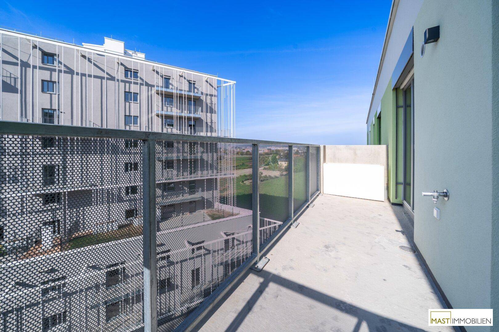 Geräumiger Balkon mit weitem Blick über die Stadt und die umliegenden Gebäude.