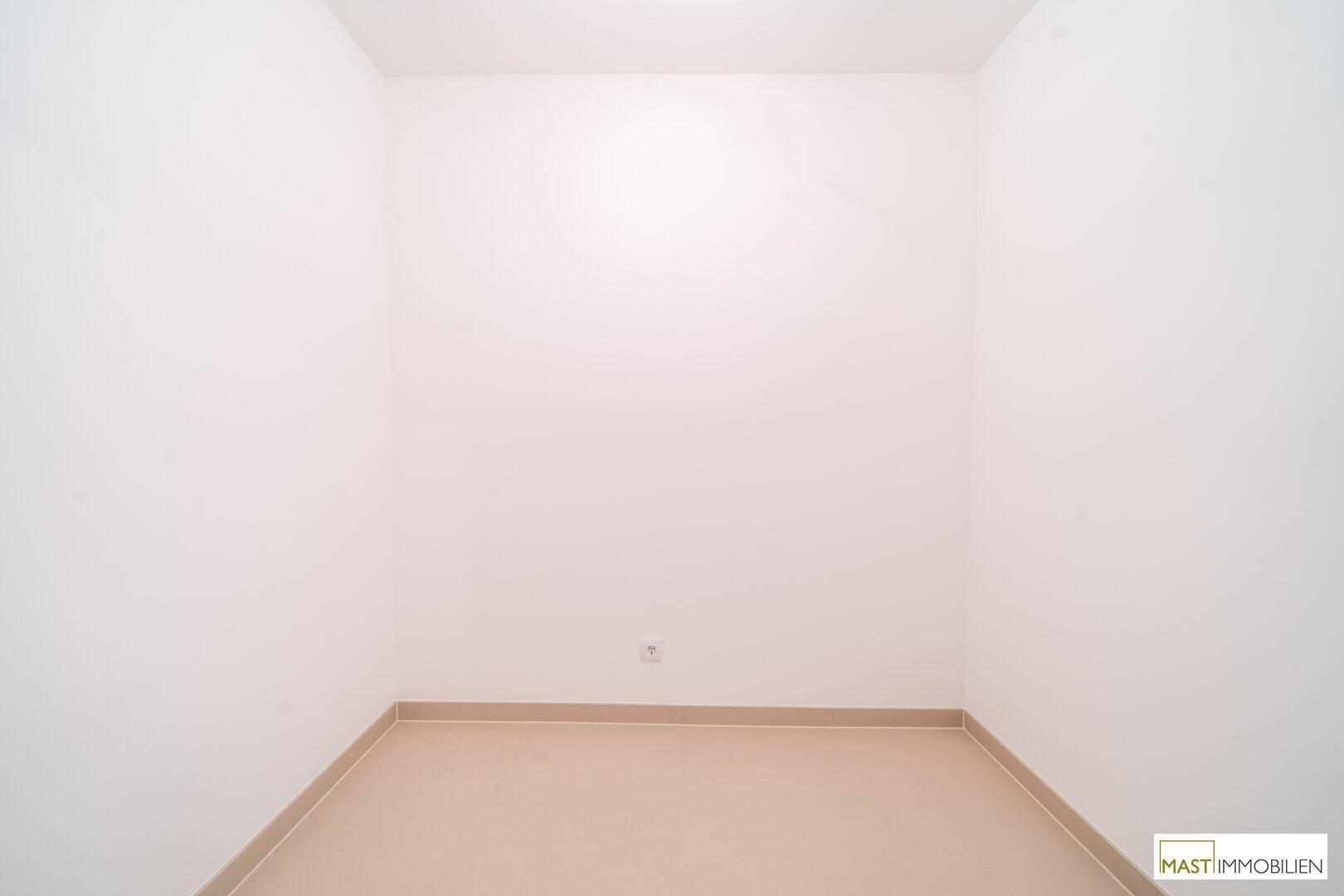 Kleiner, leerer Raum mit Fliesenboden und weißen Wänden, ideal als Abstell- oder Hauswirtschaftsraum.