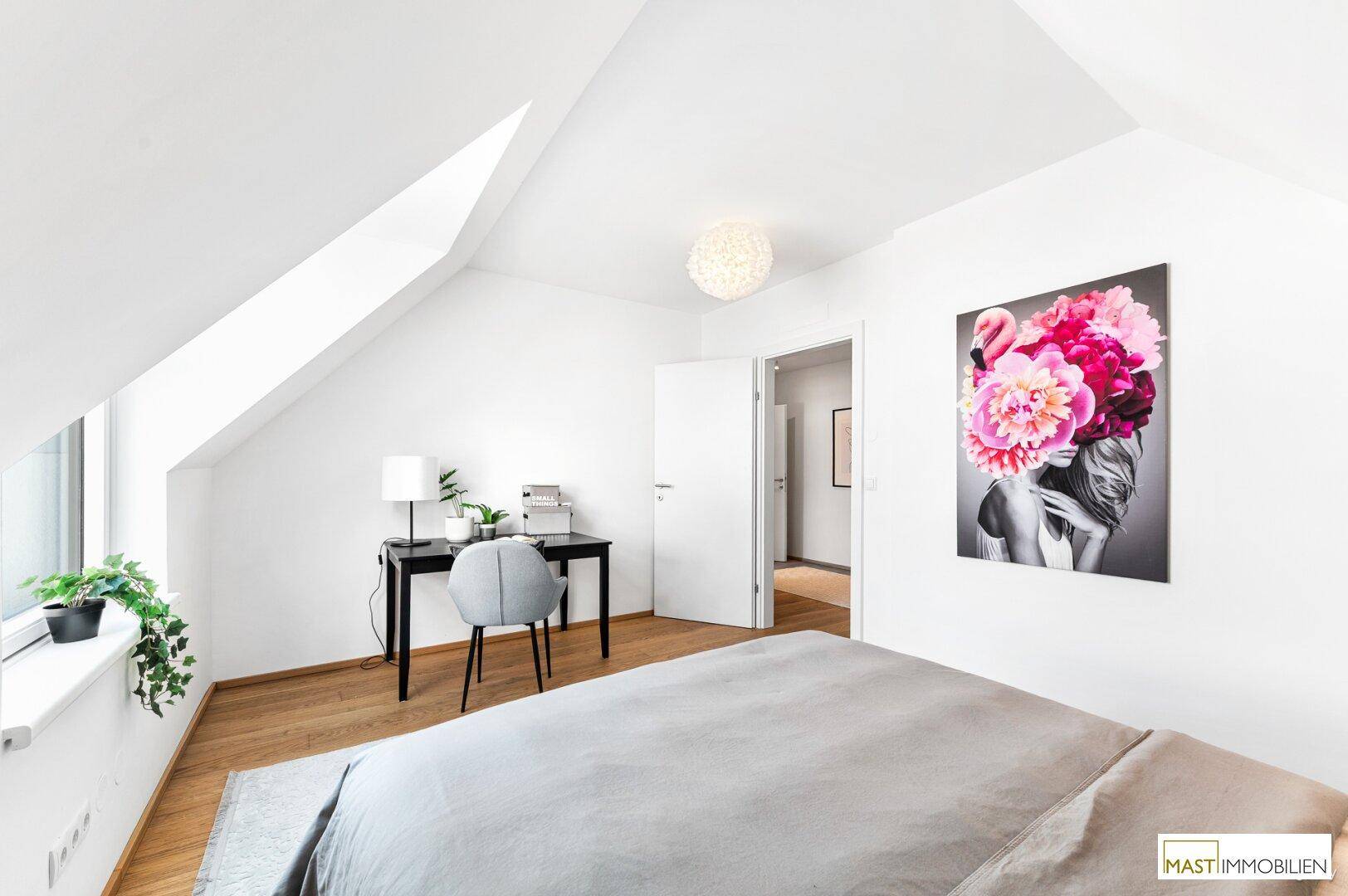 Modernes Schlafzimmer mit Bett, Schreibtisch und farbenfrohem Kunstwerk an der Wand.
