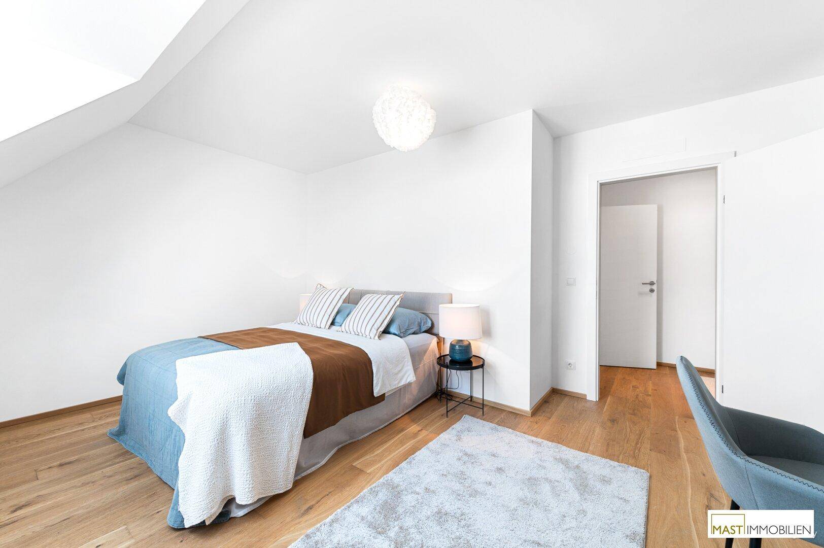 Helles Schlafzimmer mit Holzboden, bequemen Bett und modernem Design im Dachgeschoss.