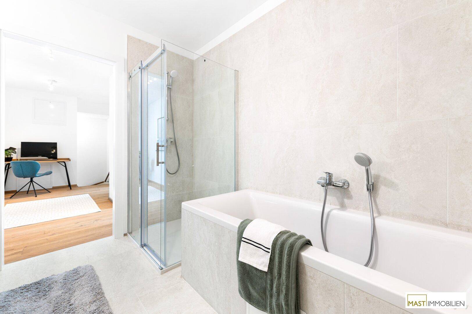 Badezimmer mit Badewanne und separater Duschkabine, verbunden mit einem angrenzenden Raum.