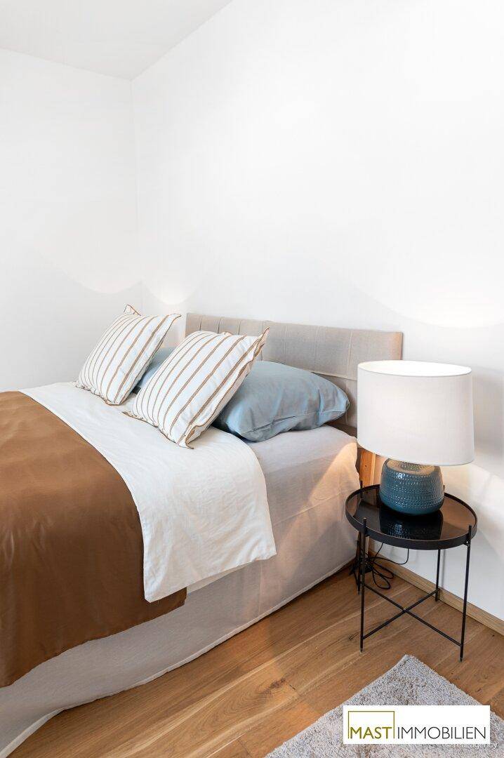 Gemütliches Schlafzimmer mit großem Bett, Nachttisch und Leselampe, ideal für entspannte Nächte.