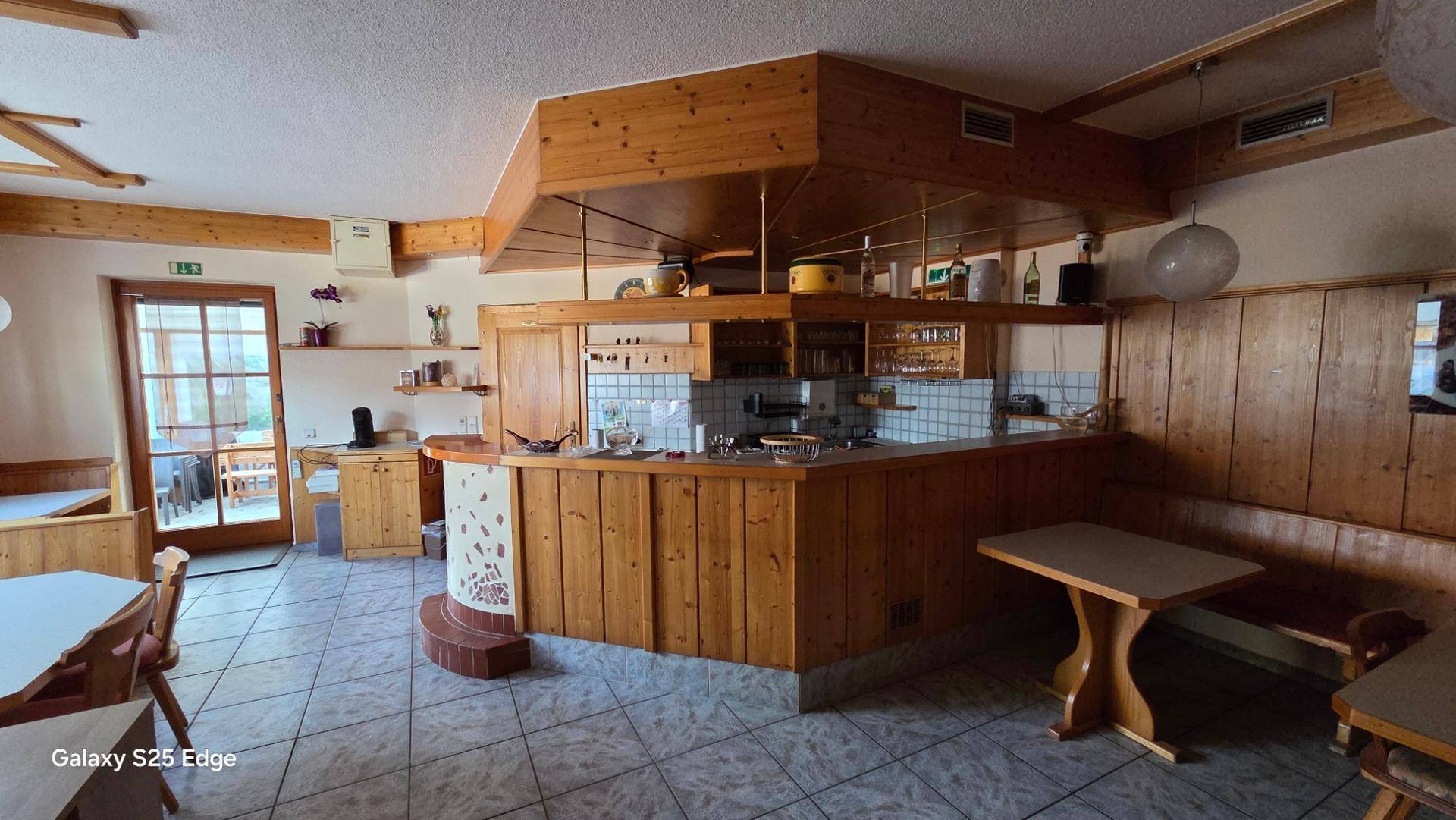 Rustikale Küche mit Holzvertäfelung, gefliestem Boden und einer Theke.