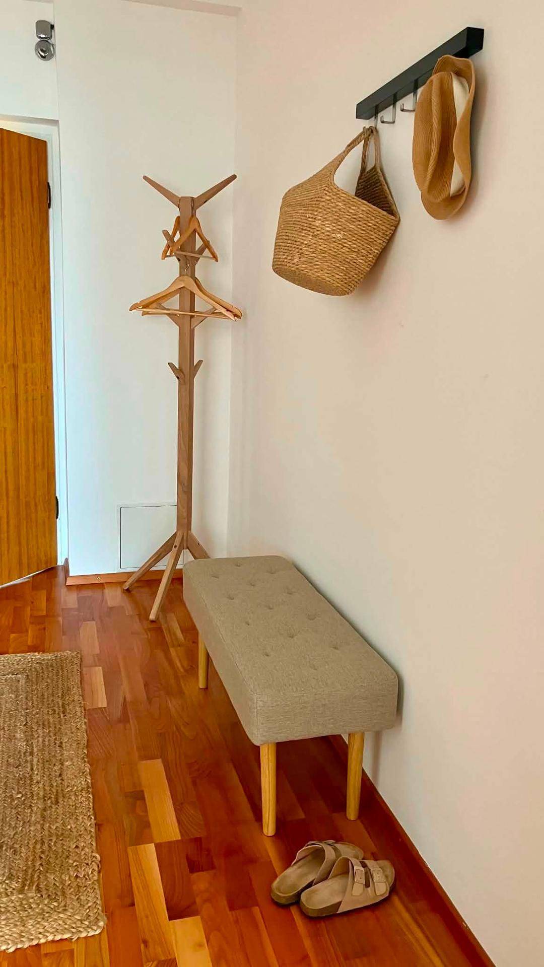 Detailansicht des Flurs mit Sitzbank, Garderobe und Holzboden.