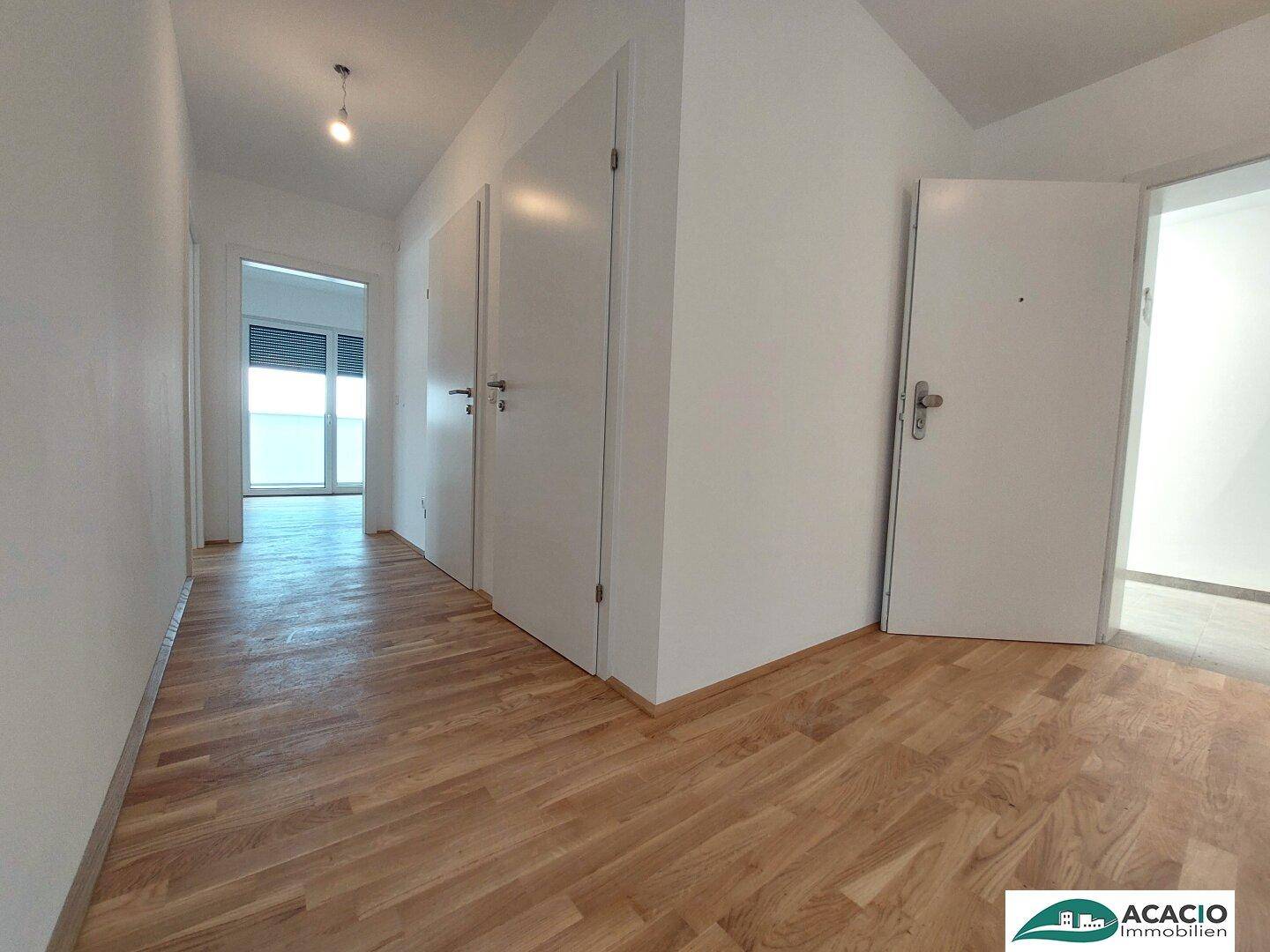 Eingangsbereich mit Parkettboden und mehreren Türen zu den angrenzenden Zimmern der Wohnung.