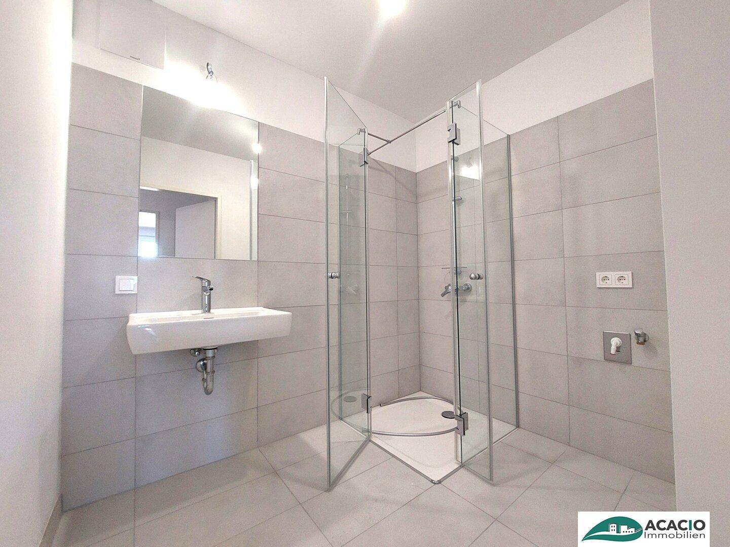 Modernes Badezimmer mit großformatigen Fliesen, begehbarer Dusche und Einzelwaschbecken.