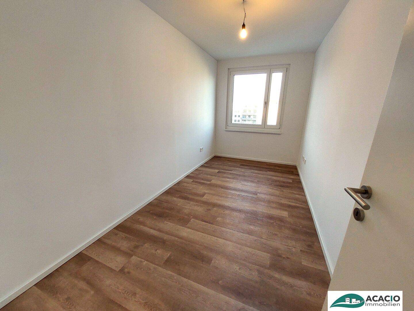 Kleineres Zimmer mit Laminatboden und einem Fenster, ideal als Gäste- oder Arbeitszimmer.