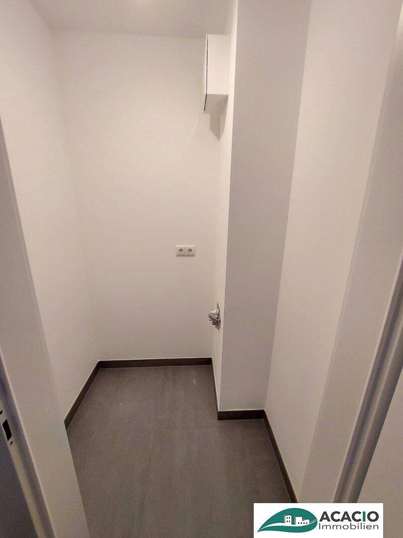 Schmaler Hauswirtschaftsraum mit Fliesenboden und Anschlüssen für Waschmaschine oder Trockner.