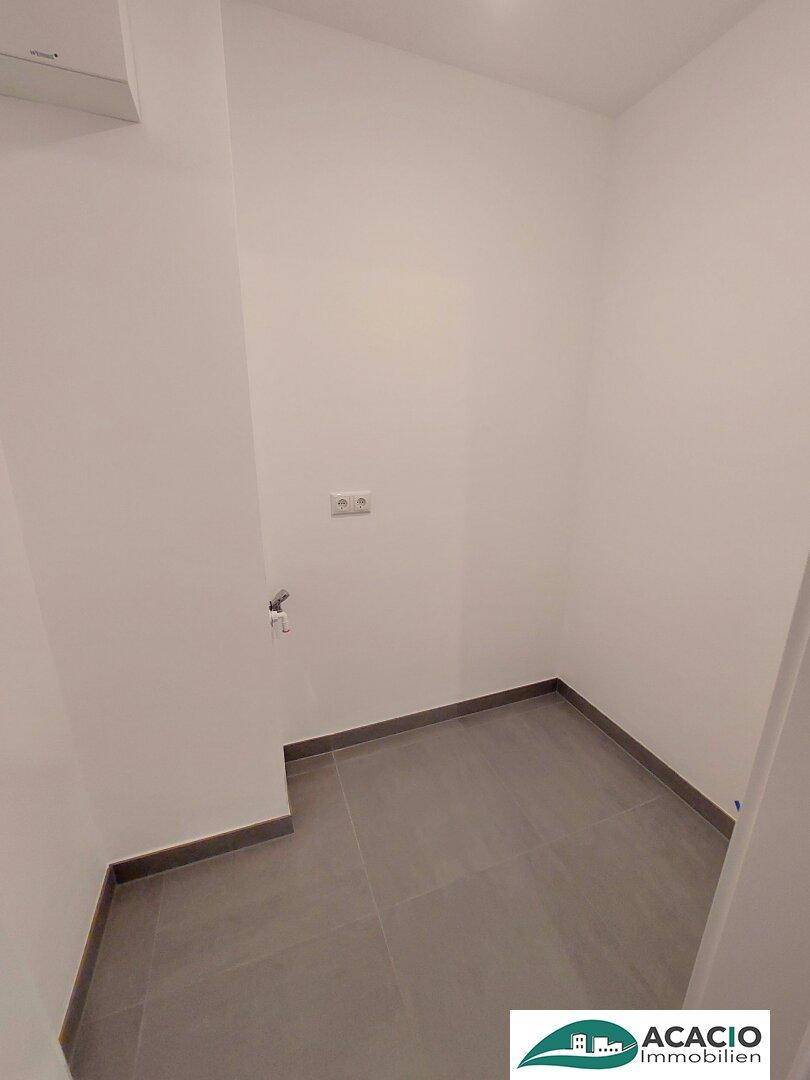 Praktischer Hauswirtschaftsraum mit Fliesenboden und Anschlüssen für Waschmaschine oder Trockner.