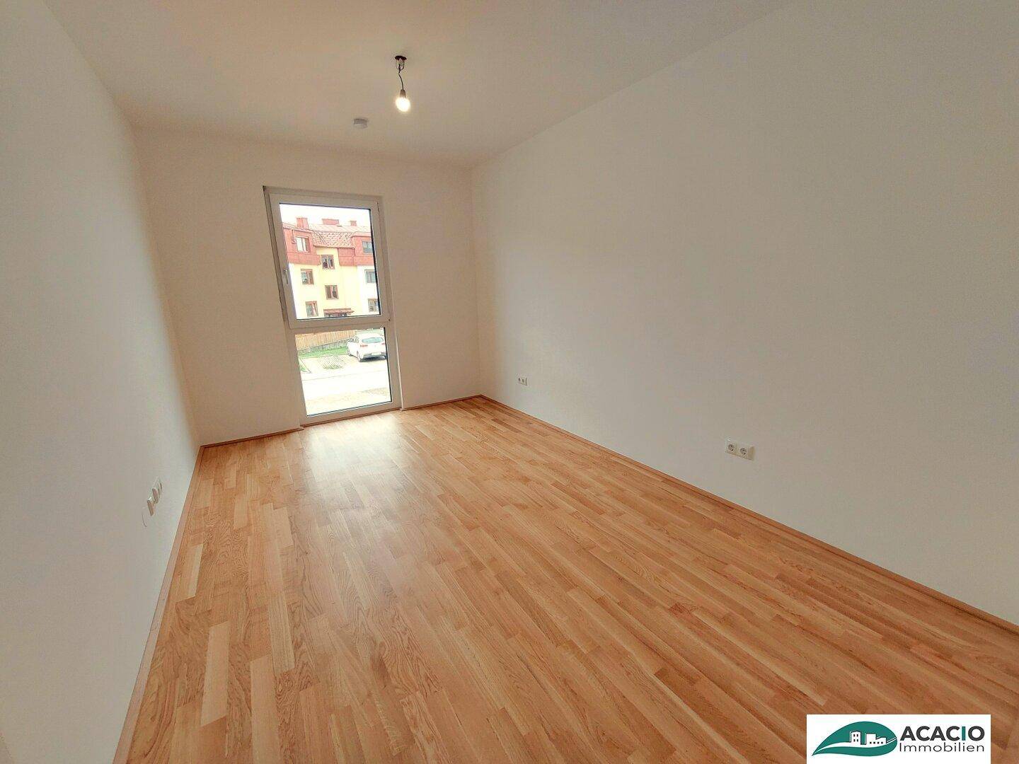 Unmöbliertes Zimmer mit Parkettboden und Fenster, geeignet als Schlaf- oder Arbeitszimmer.