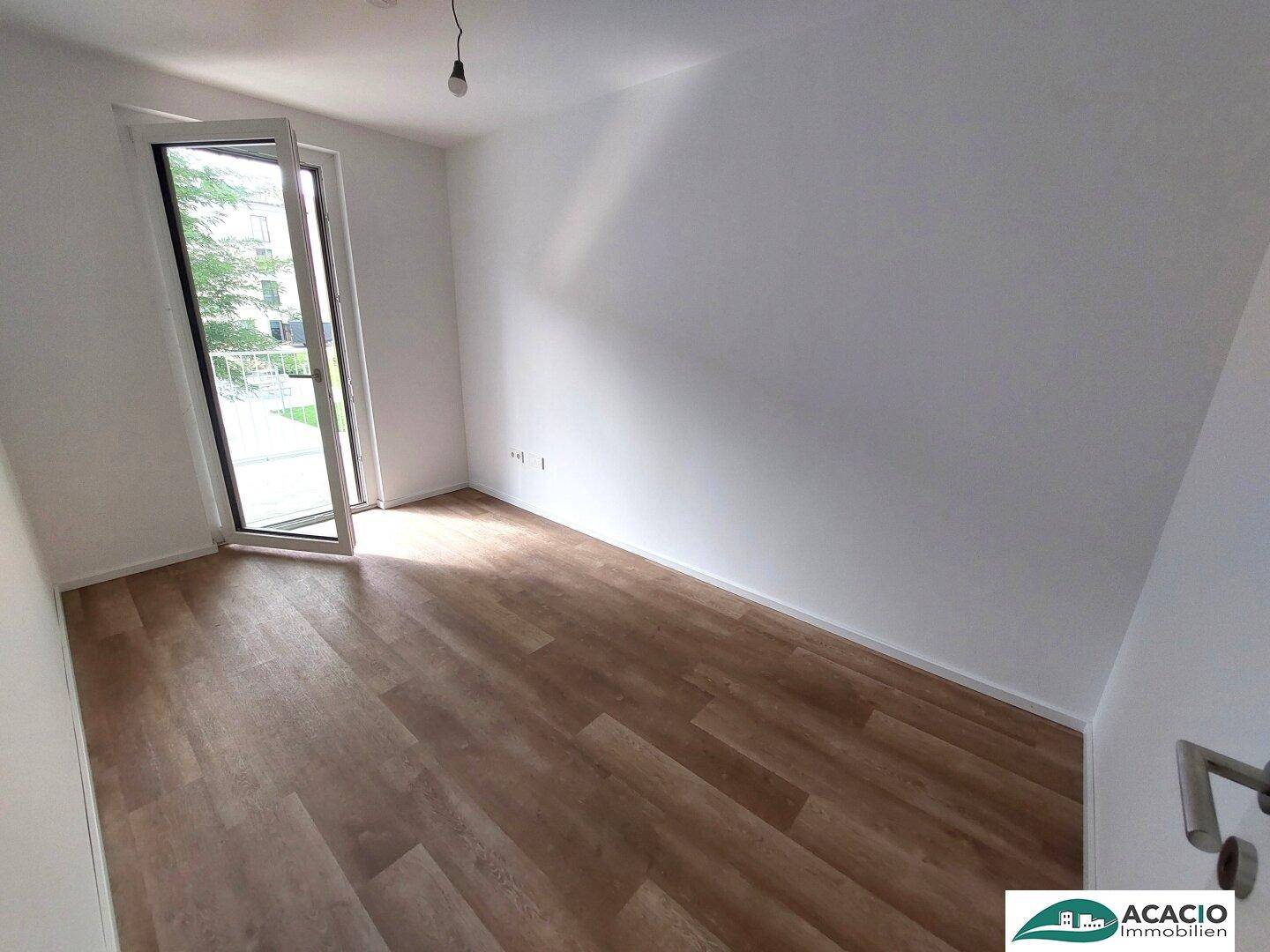 Helles Zimmer mit Laminatboden und direktem Zugang zum Außenbereich.