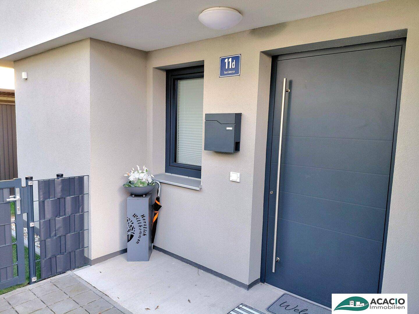 Moderner Hauseingang mit dunkler Tür, Hausnummer und Briefkasten in schlichtem Design.