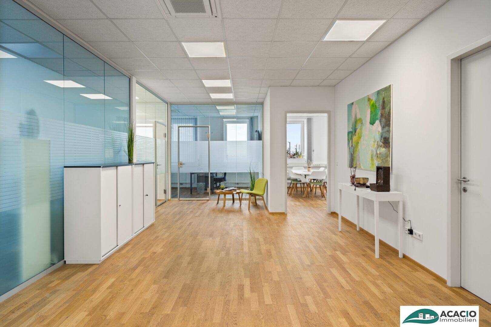 Moderner Bürobereich mit Glaswänden, Holzfußboden und hellem Empfangsbereich, ideal für Unternehmen.