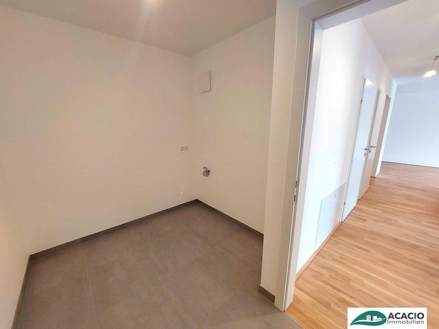 Praktischer Hauswirtschaftsraum mit Fliesenboden und Anschlüssen für Waschmaschine oder Trockner.