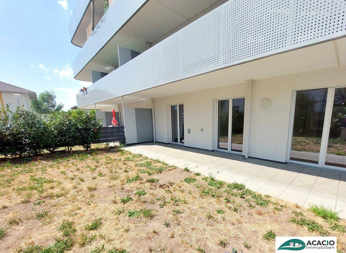 Garten und Terrasse im Erdgeschoss mit Zugang zu den Wohnräumen eines Neubaus.