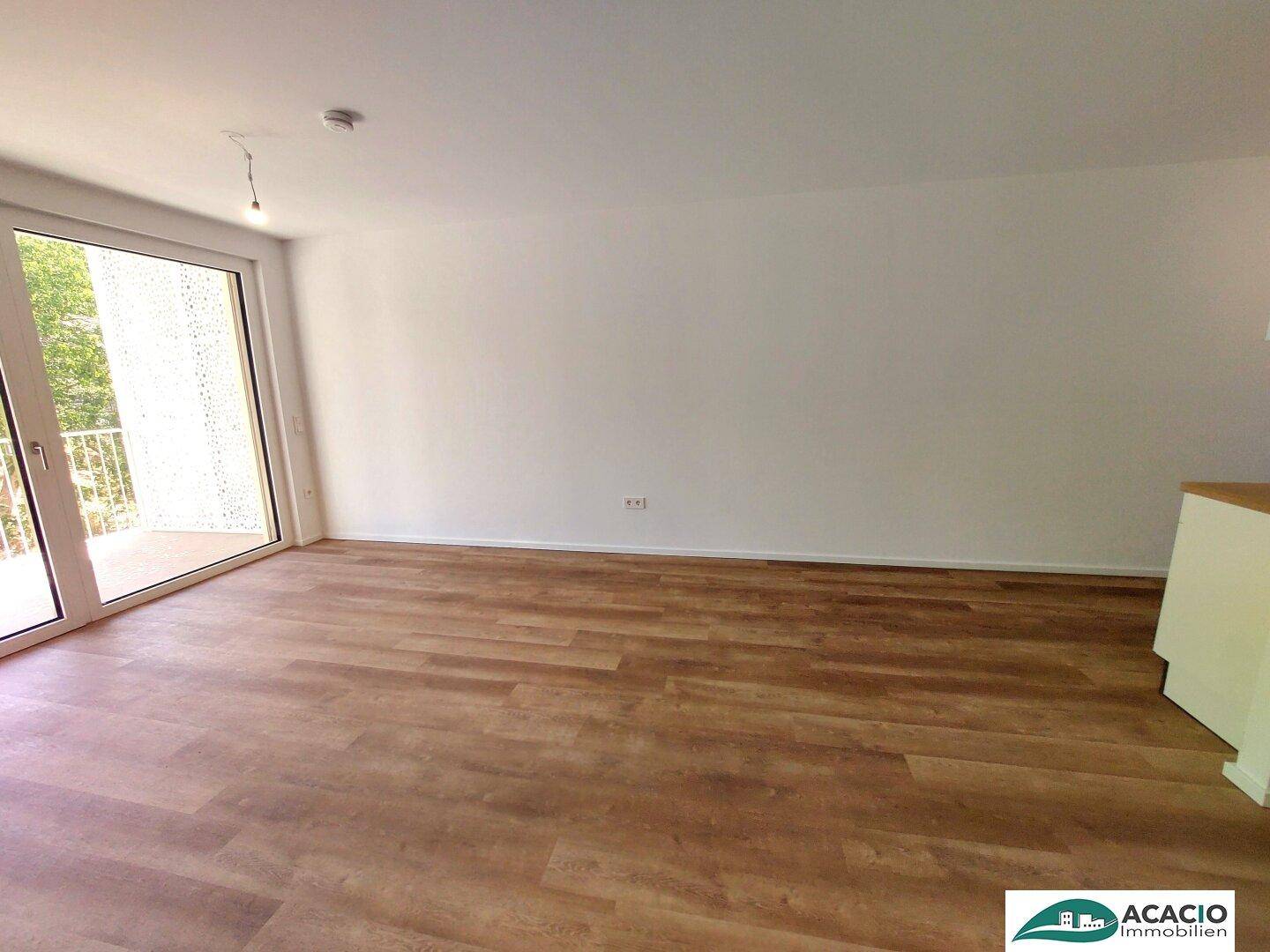 Heller Wohnbereich mit direktem Zugang zum Balkon, ideal für entspannte Stunden im Freien.