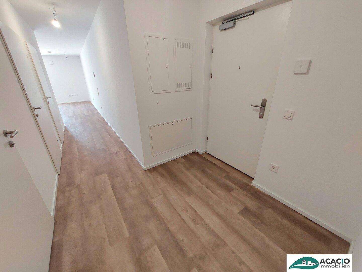 Heller Eingangsbereich mit Vinylboden und weiß gestrichenen Wänden.