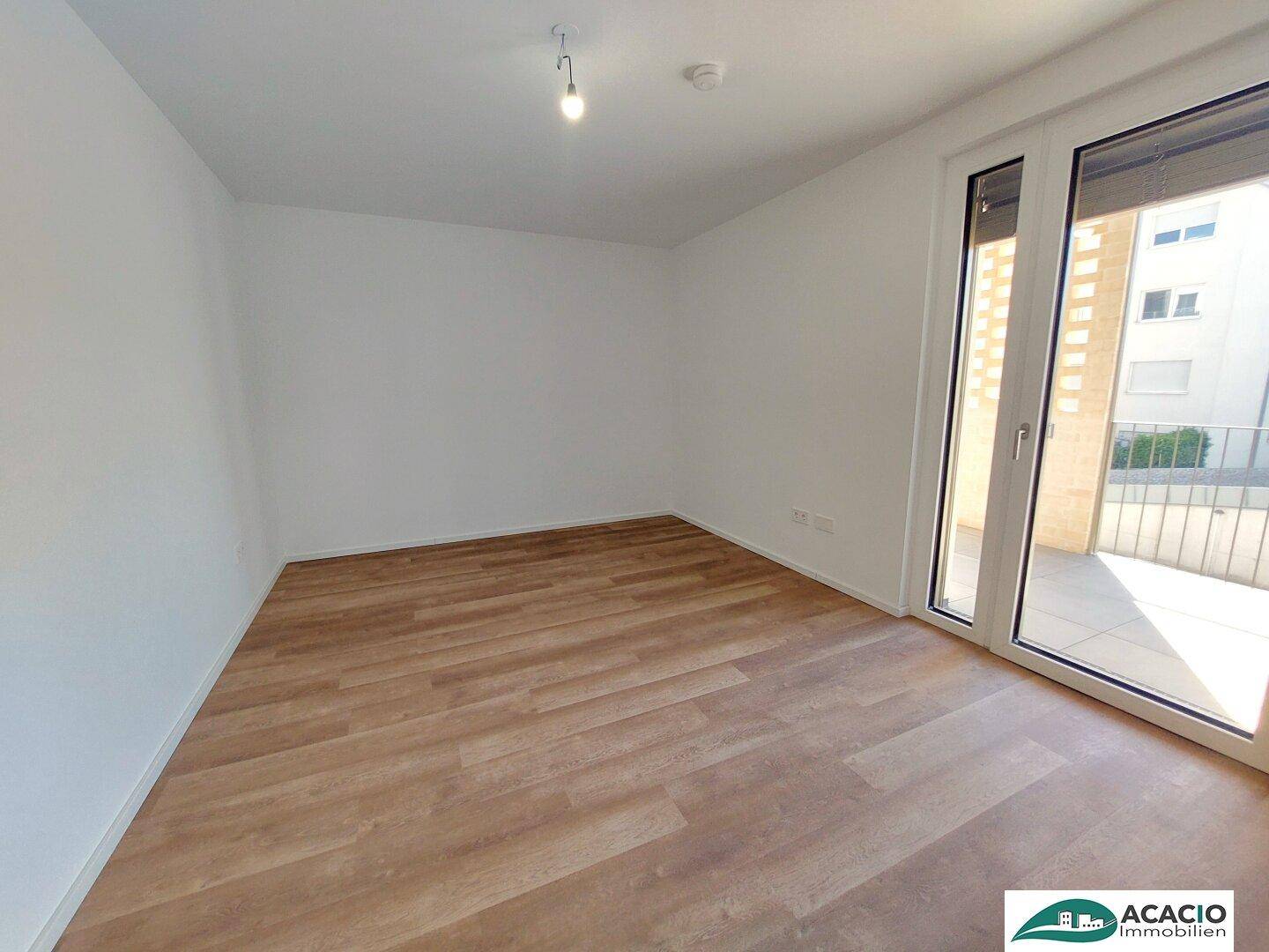 Geräumiges Schlafzimmer mit großen Fenstern und viel natürlichem Licht.