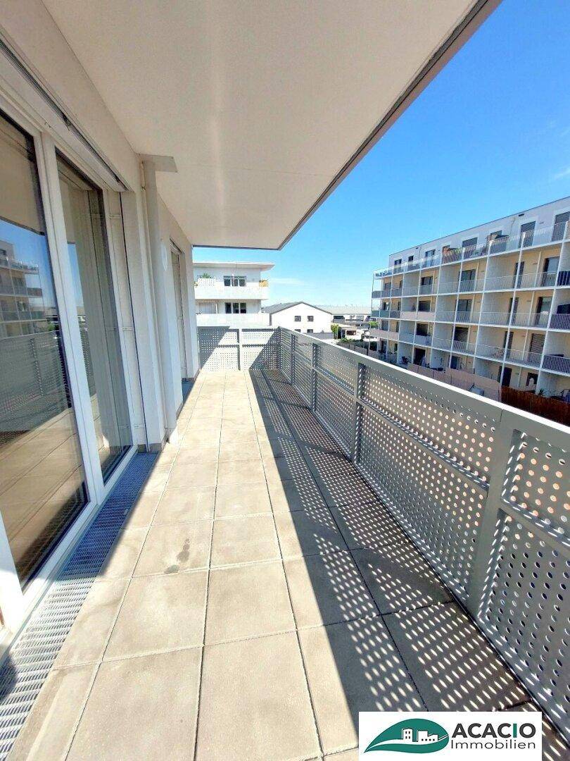 Langer Balkon mit Fliesenboden und modernem Metallgeländer, ideal für sonnige Tage.