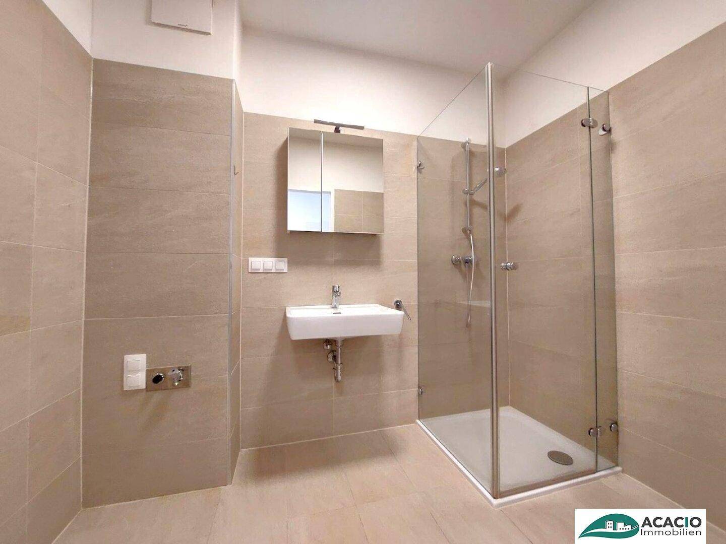 Modernes Badezimmer mit begehbarer Dusche, Einzelwaschbecken und hellen Wandfliesen.