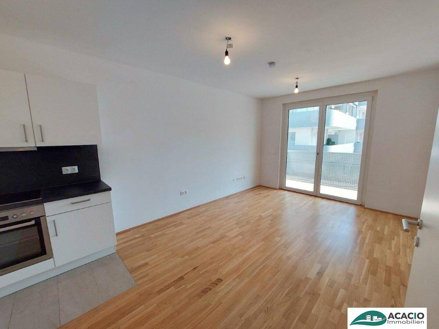 Lichtdurchfluteter Wohnbereich mit Zugang zum Balkon und modernem Parkettboden.