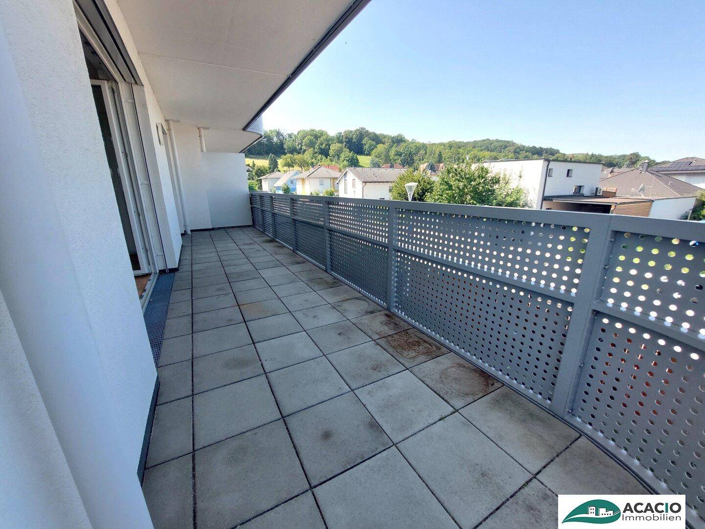 Geräumiger Balkon mit Fliesenboden und Blick ins Grüne sowie auf die Umgebung.
