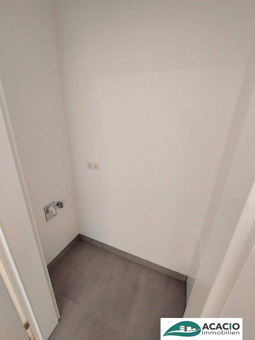 Praktischer Hauswirtschaftsraum mit Fliesenboden und Anschlüssen für Waschmaschine.