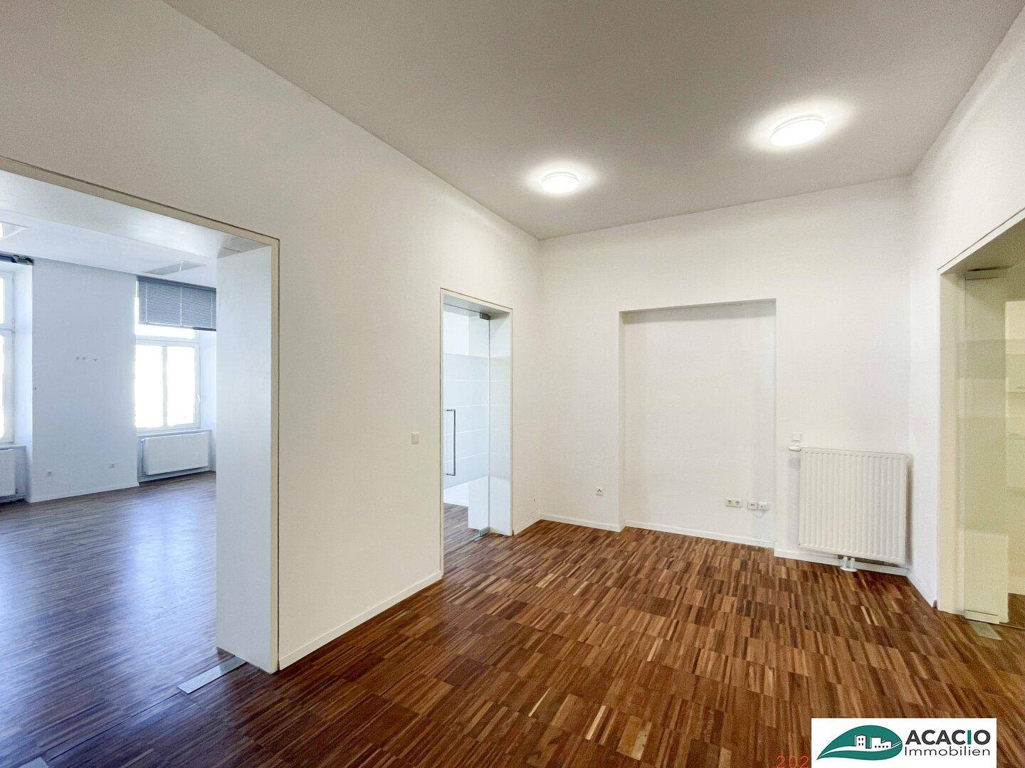 Heller Büroraum mit Holzboden und Einbaunische, ideal für flexible Nutzung.
