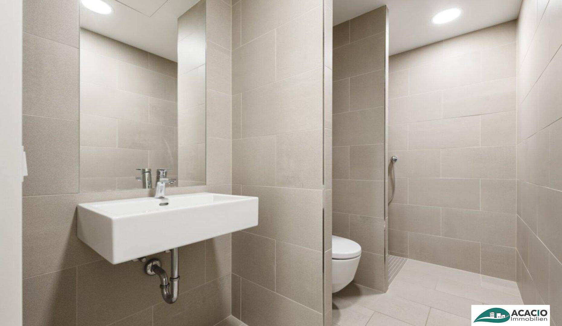 Modernes Badezimmer mit hellgrauen Fliesen, einem wandhängenden Waschbecken und einer begehbaren Dusche.