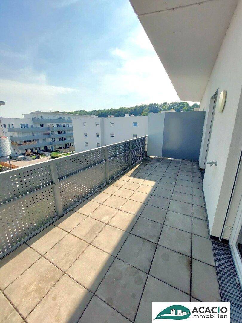 Heller Balkon mit Fliesen und weitem Blick über die Wohngegend.