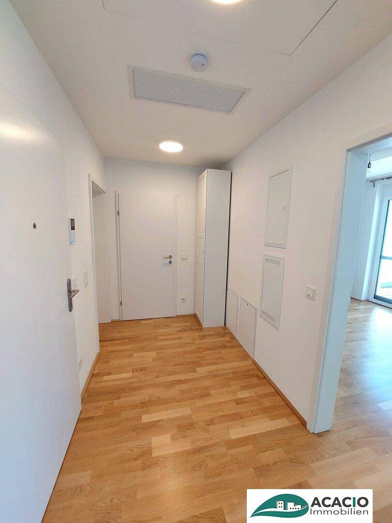Geräumiger Eingangsbereich mit hellem Holzboden und Zugang zu den Wohnräumen.