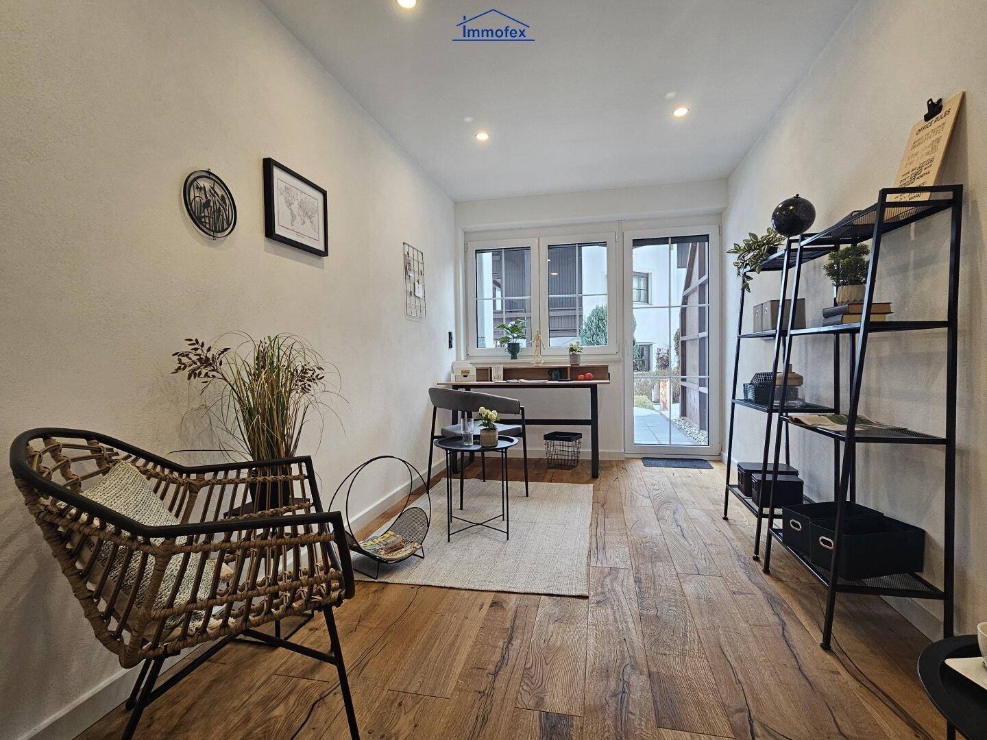 Helles Arbeitszimmer mit Holzboden und Zugang zum Außenbereich, ideal für Home-Office.