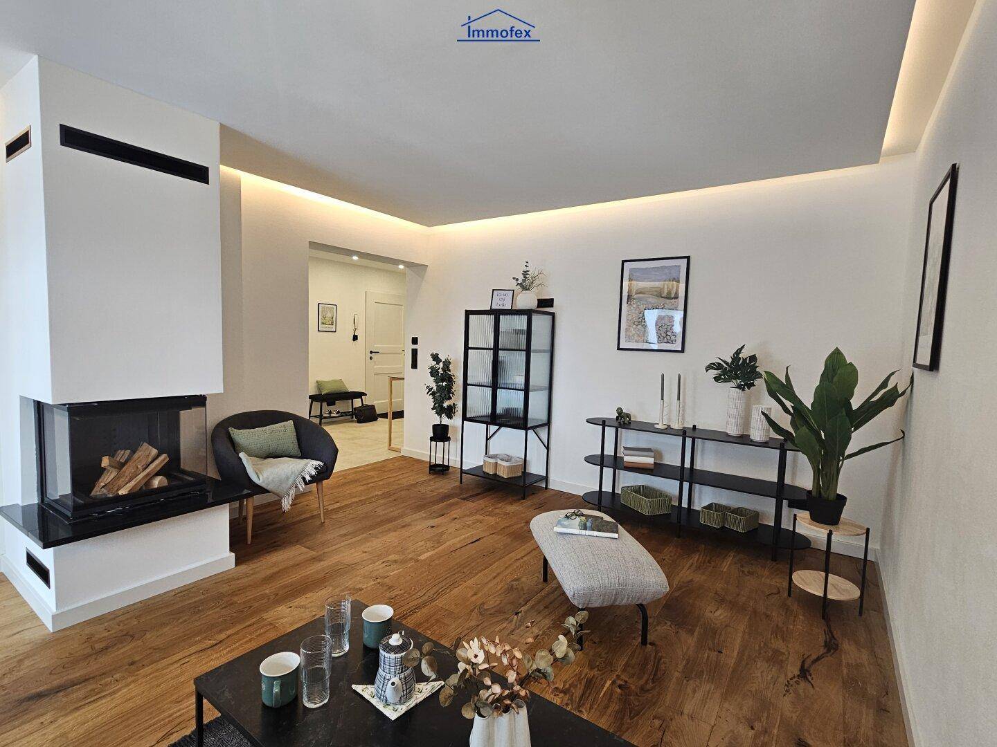 Geräumiges Wohnzimmer mit Kamin, Holzboden und stilvoller Einrichtung, perfekt zum Entspannen.