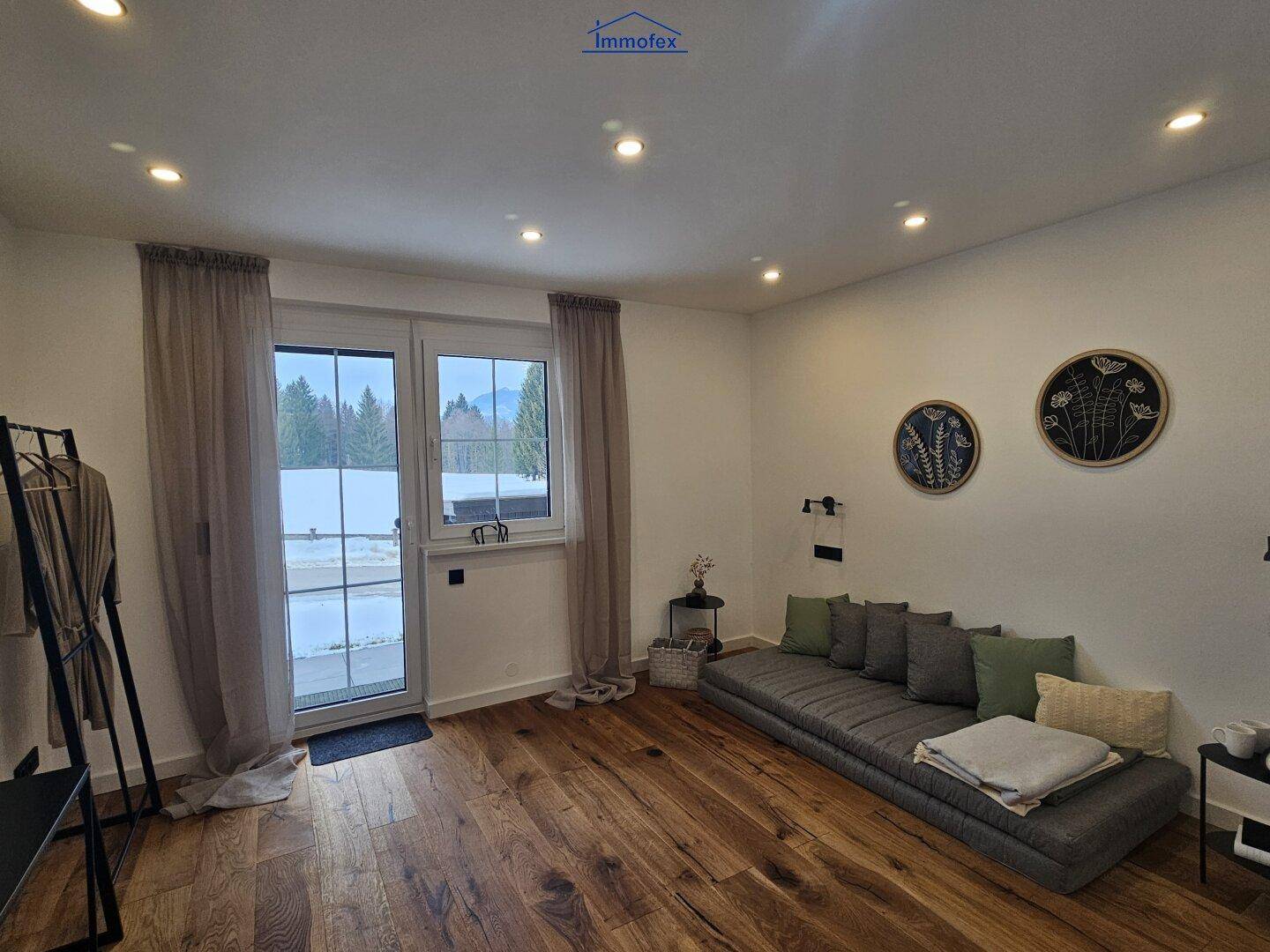 Gemütliches Schlafzimmer mit Holzboden und Zugang zum Balkon, ideal für erholsame Nächte.