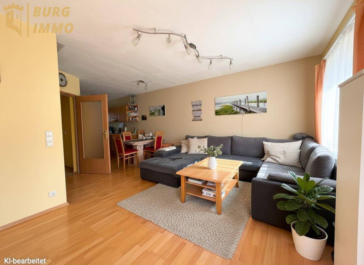 Gemütlicher Wohn-Essbereich mit Parkettboden, großem Sofa und Essgruppe für gesellige Stunden.
