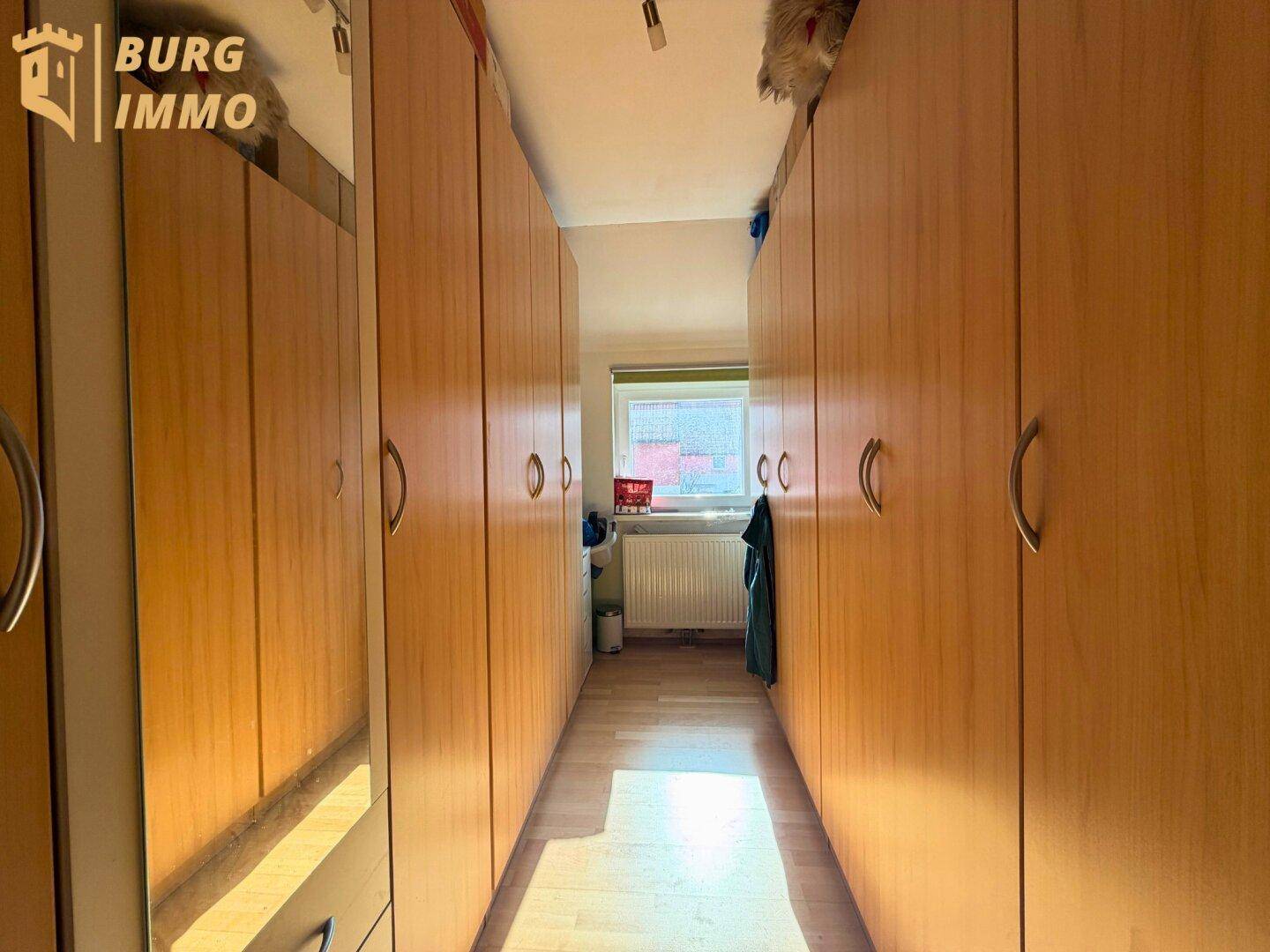 Praktischer Flur mit Einbauschränken und Fenster, bietet viel Stauraum.