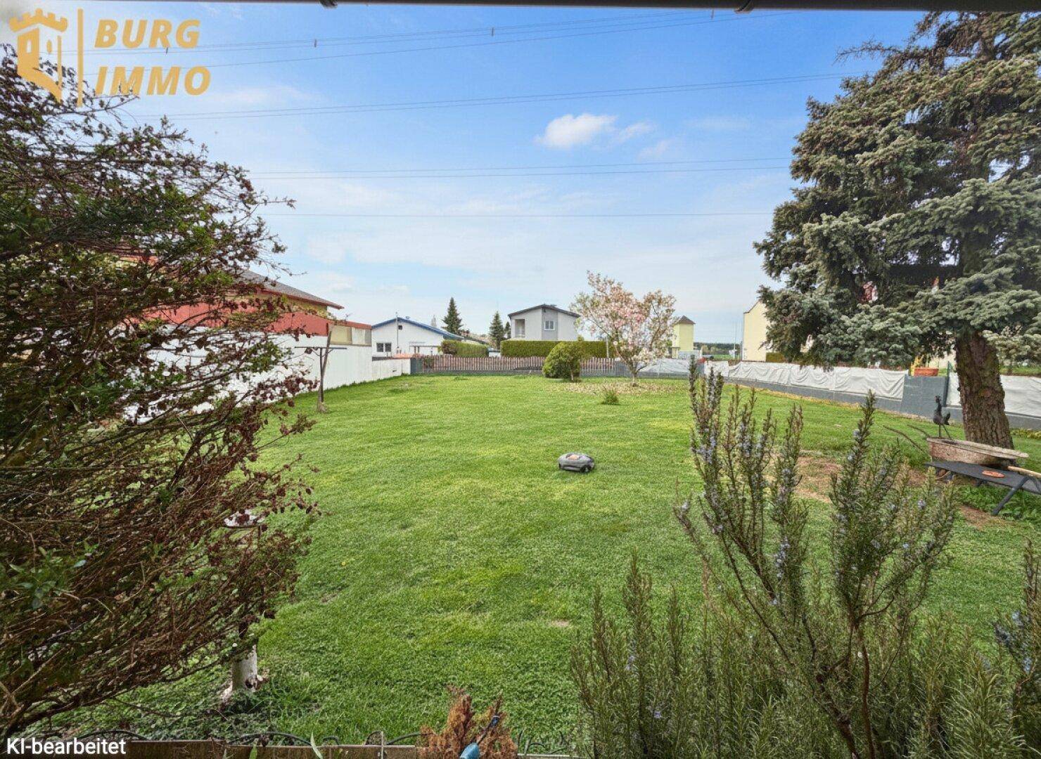 Gepflegter Rasen im Garten mit Blick auf die Nachbarschaft und einen Mähroboter.