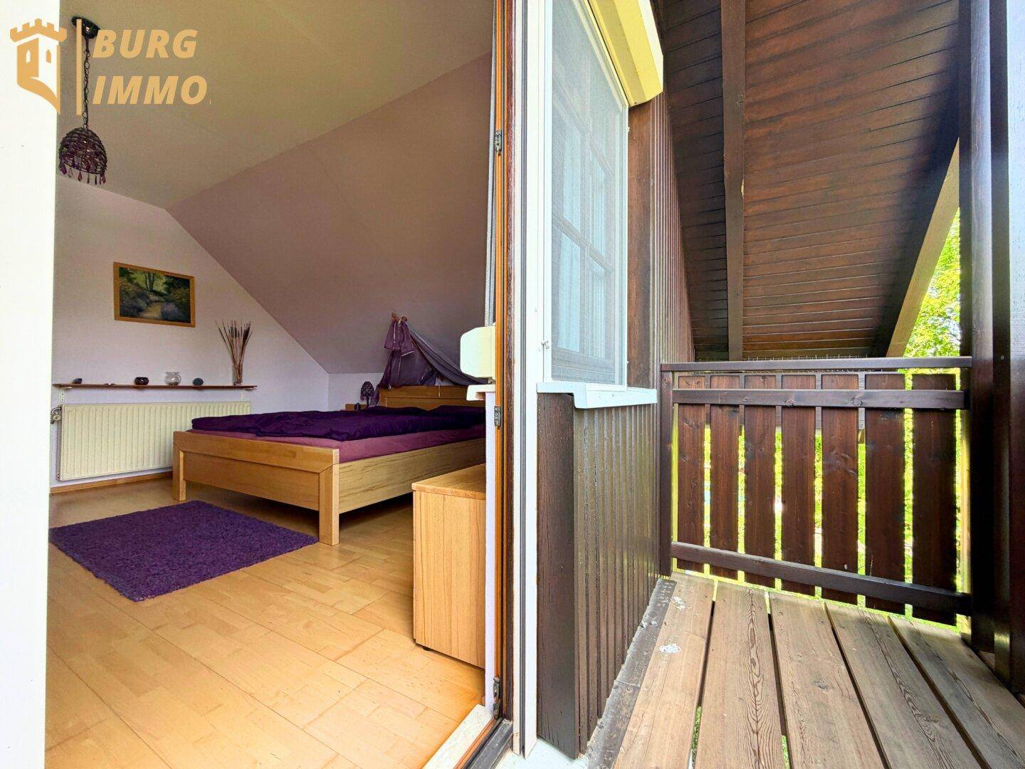 Schlafzimmer mit Holzboden und direktem Zugang zu einem überdachten Holzbalkon.