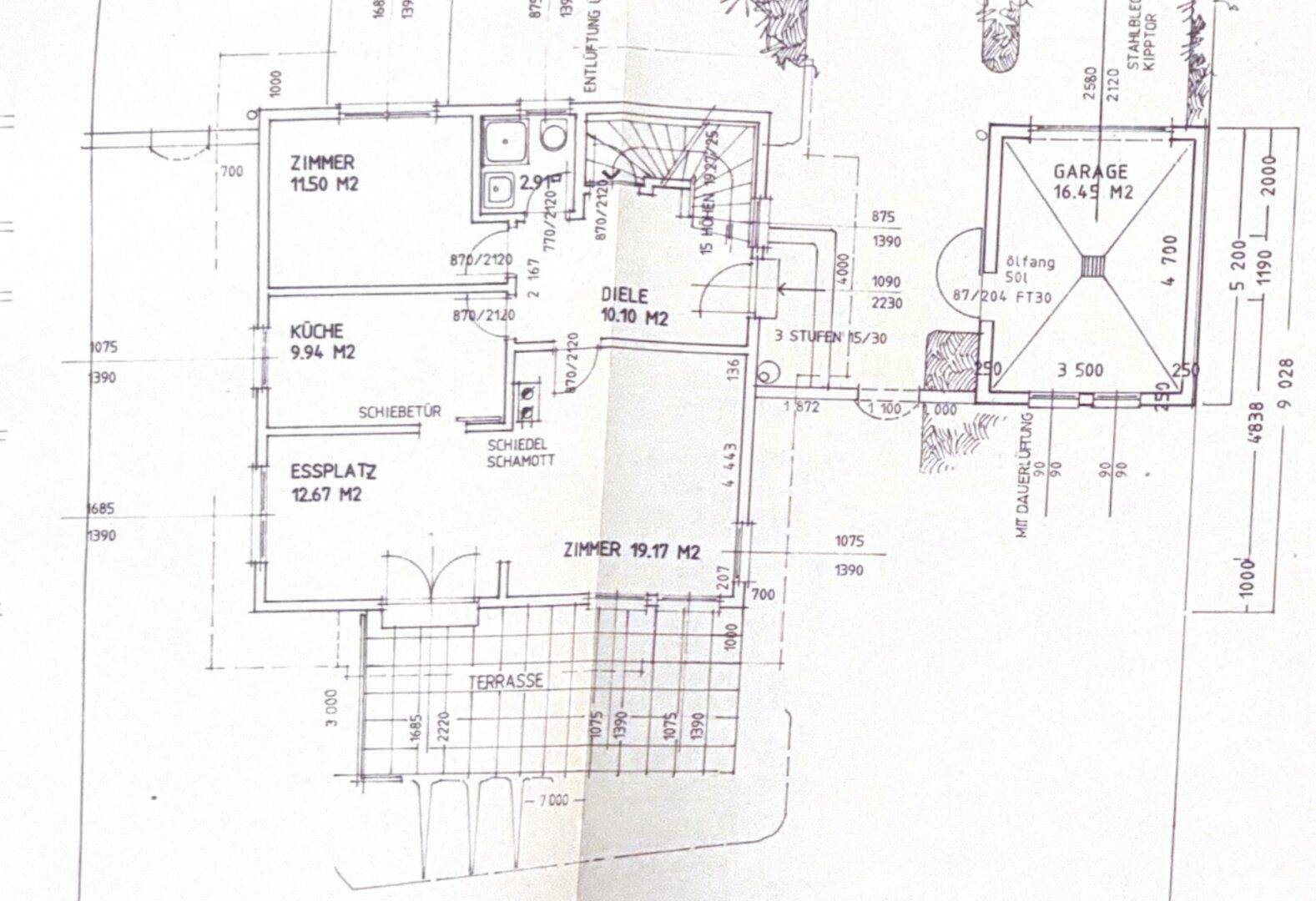 Grundriss eines Hauses mit mehreren Zimmern, Küche, Essplatz, Diele, Terrasse und einer separaten Garage.