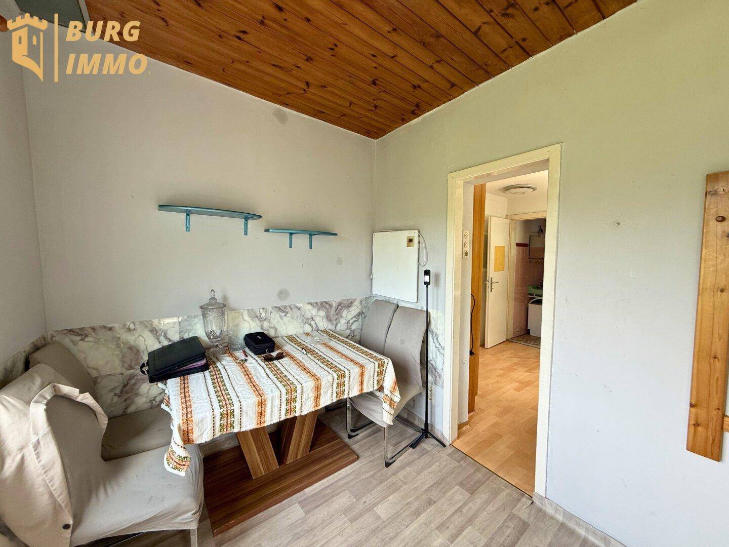 Essbereich mit Holztäfelung an der Decke, Eckbank und einem Esstisch.