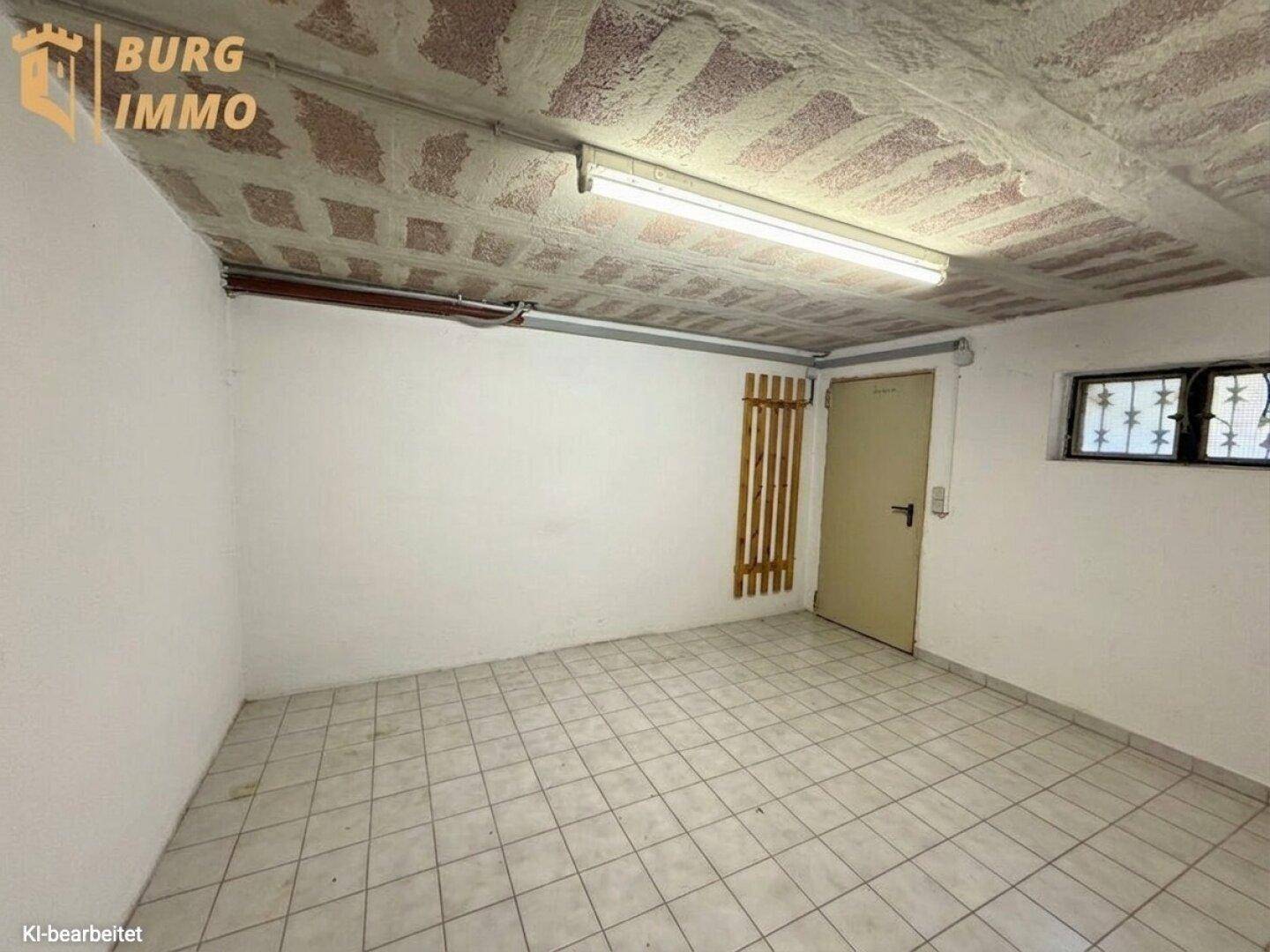 Geräumiger Kellerraum mit Fliesenboden, weiß gestrichenen Wänden und Fenster.